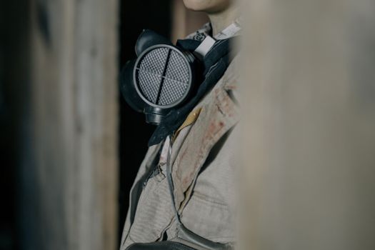 A person wearing a respirator in a dimly lit urban environment, conveying themes of survival and isolation.