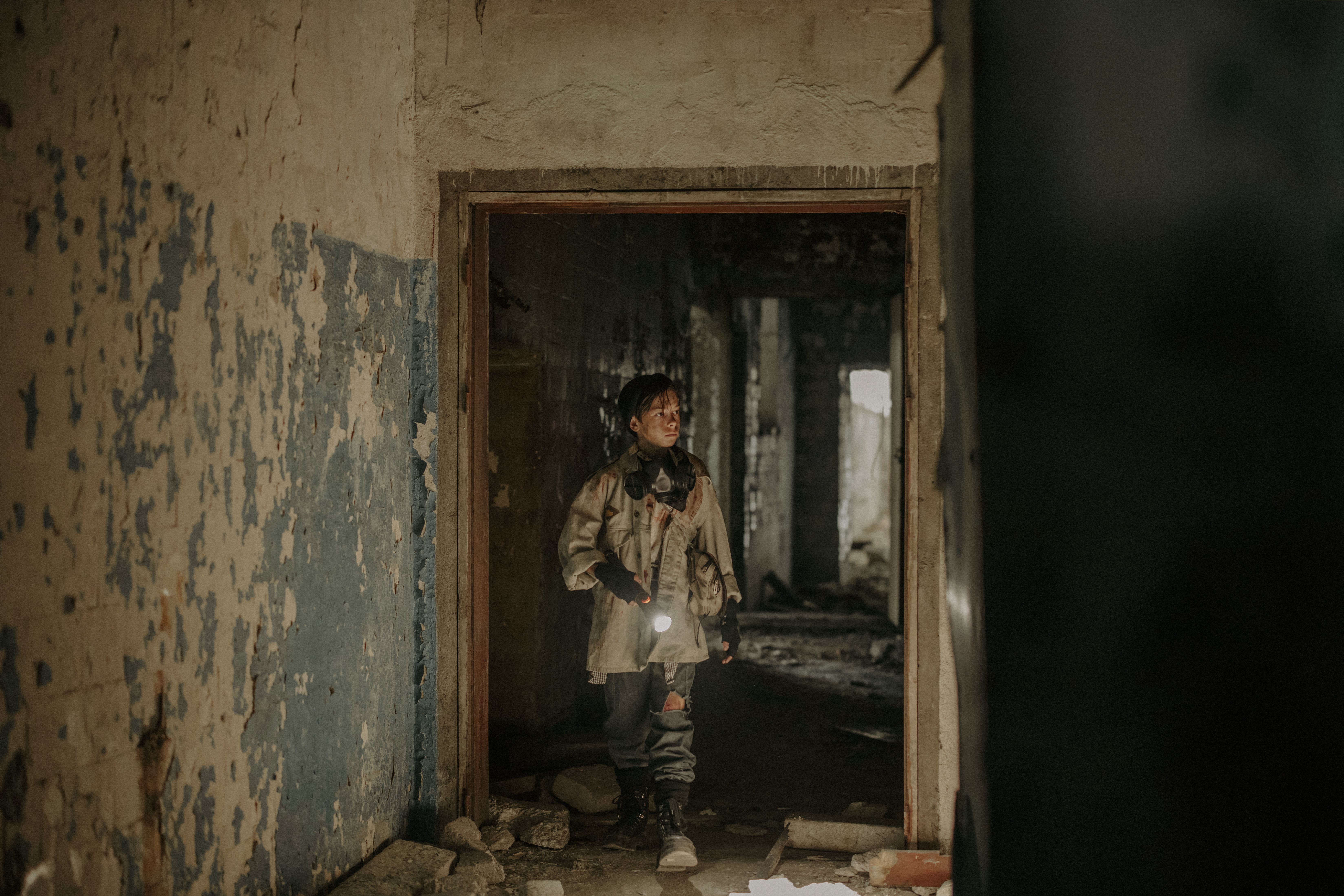 A person exploring an abandoned building with a flashlight