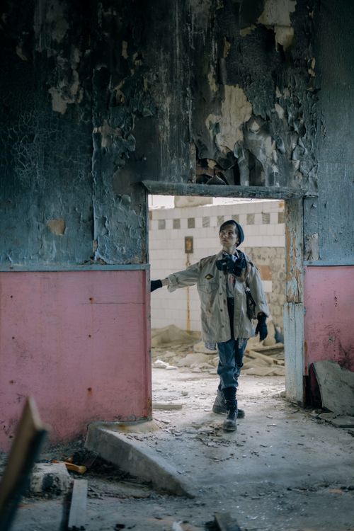 Free A young man explores a decaying urban building, conveying themes of survival and desolation. Stock Photo