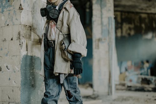 Homme En Manteau Marron Et Jeans En Denim Bleu Debout Près De Mur De Béton Blanc