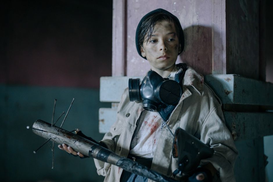 future of work skills in a post-pandemic world - Boy with gas mask and weapon in abandoned urban environment.