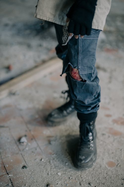 Person in Blue Denim Jeans and Black Leather Boots