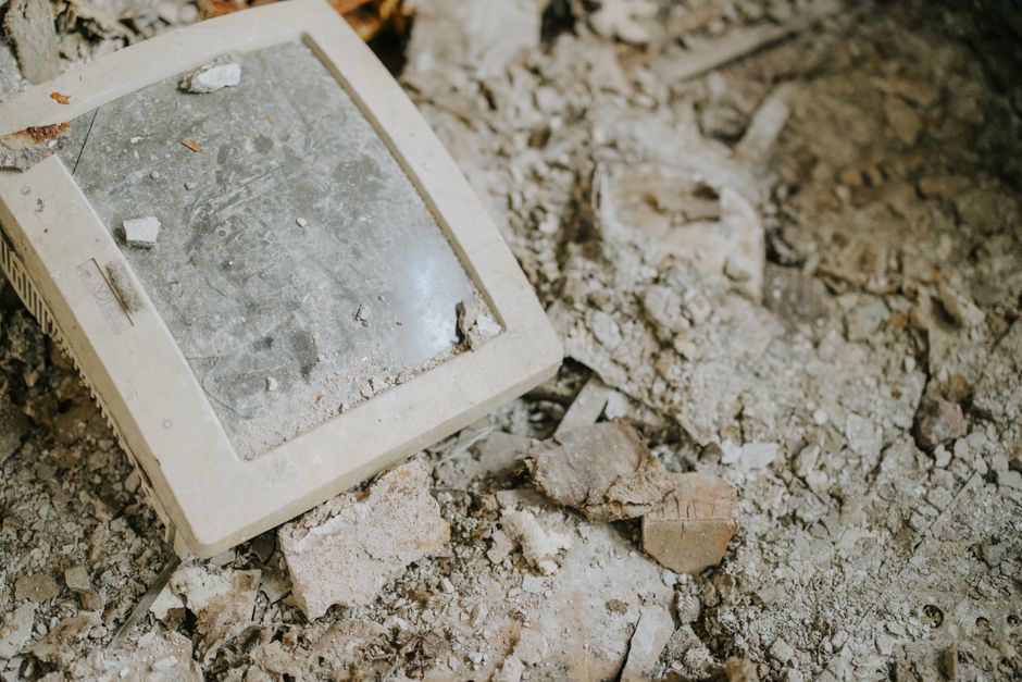 An old monitor discarded on dusty, broken rubble, symbolizing decay and obsolescence.