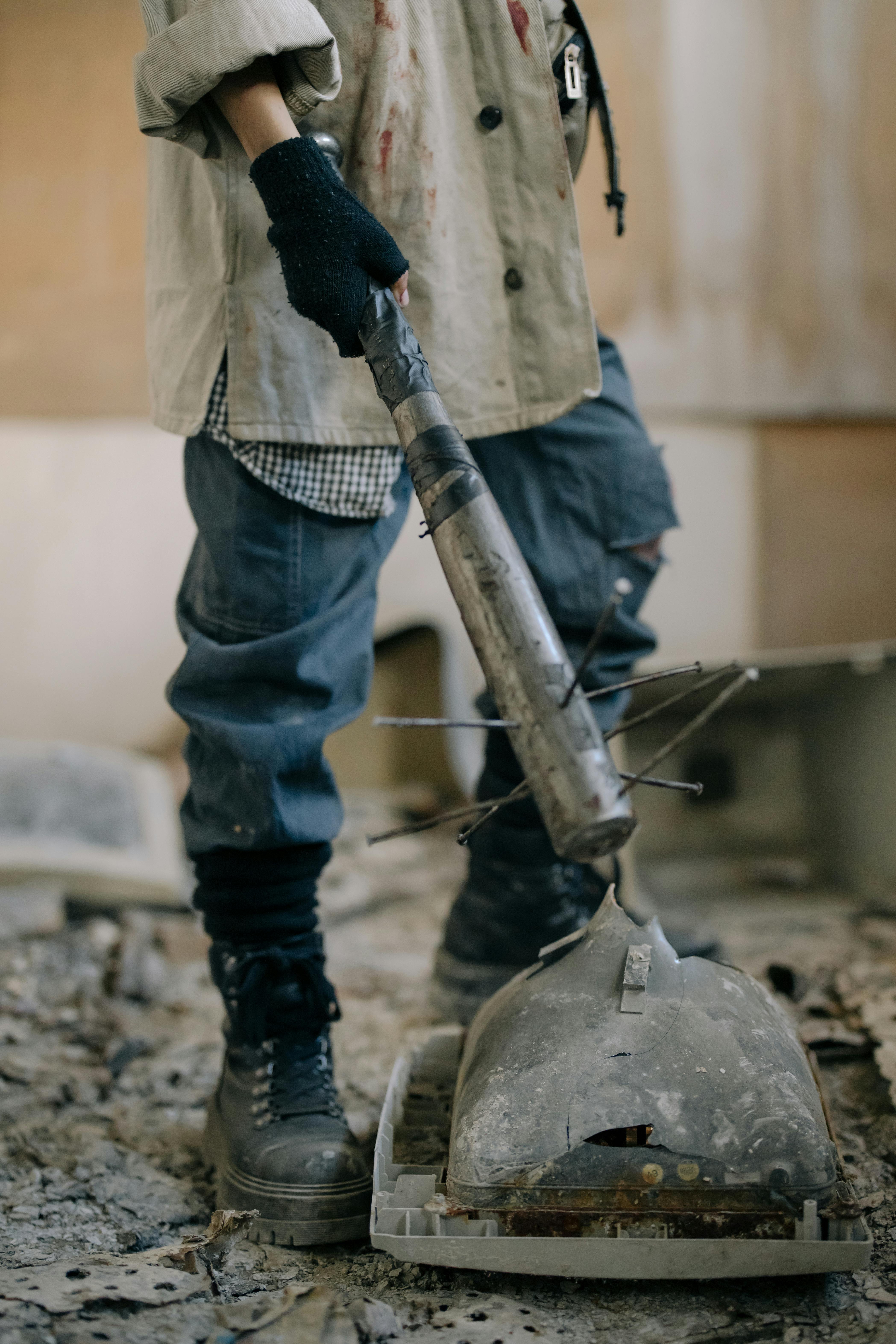 person in blue denim jeans holding gray metal kettle