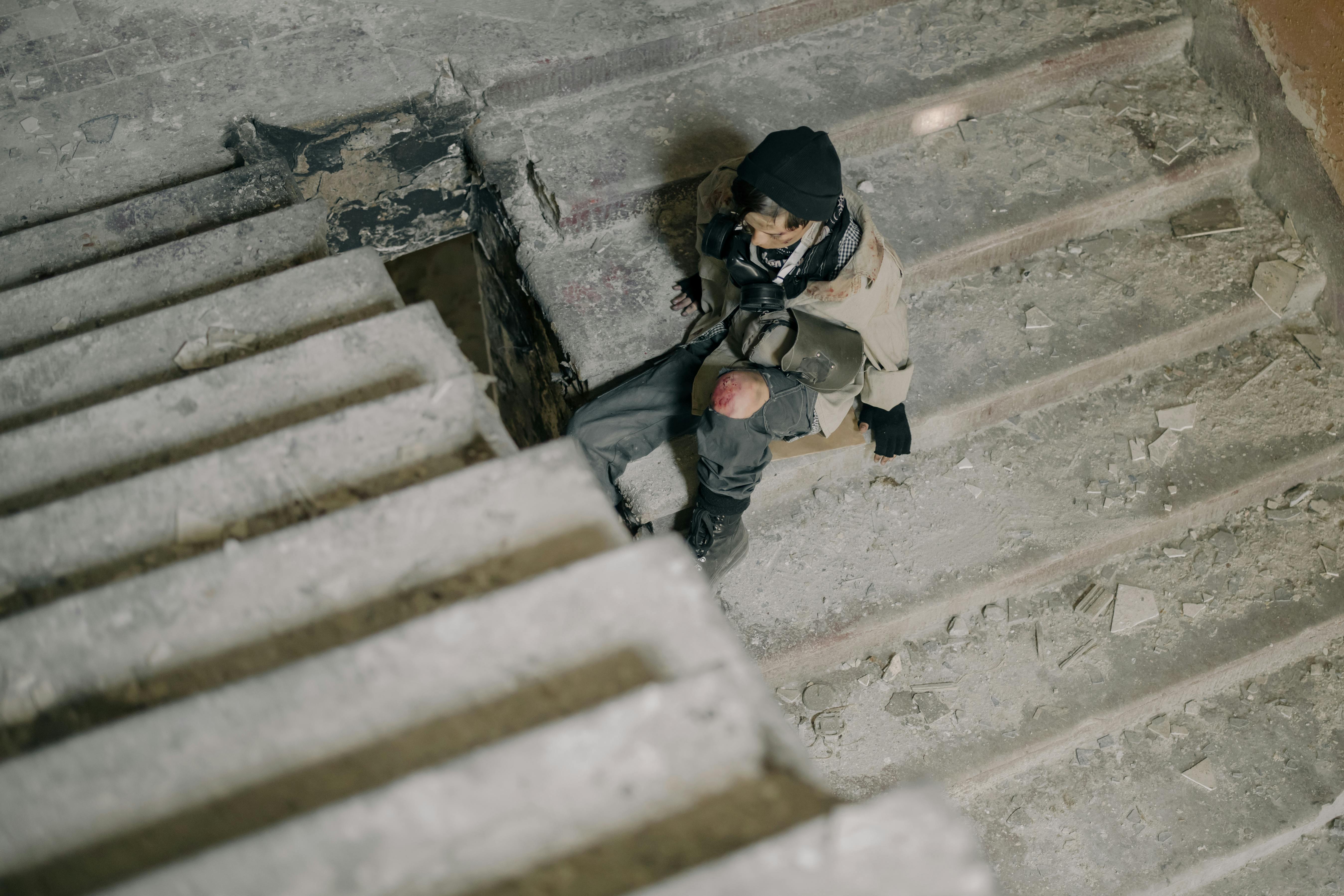 Young man in abandoned building, sitting on stairs, in post-apocalyptic setting.