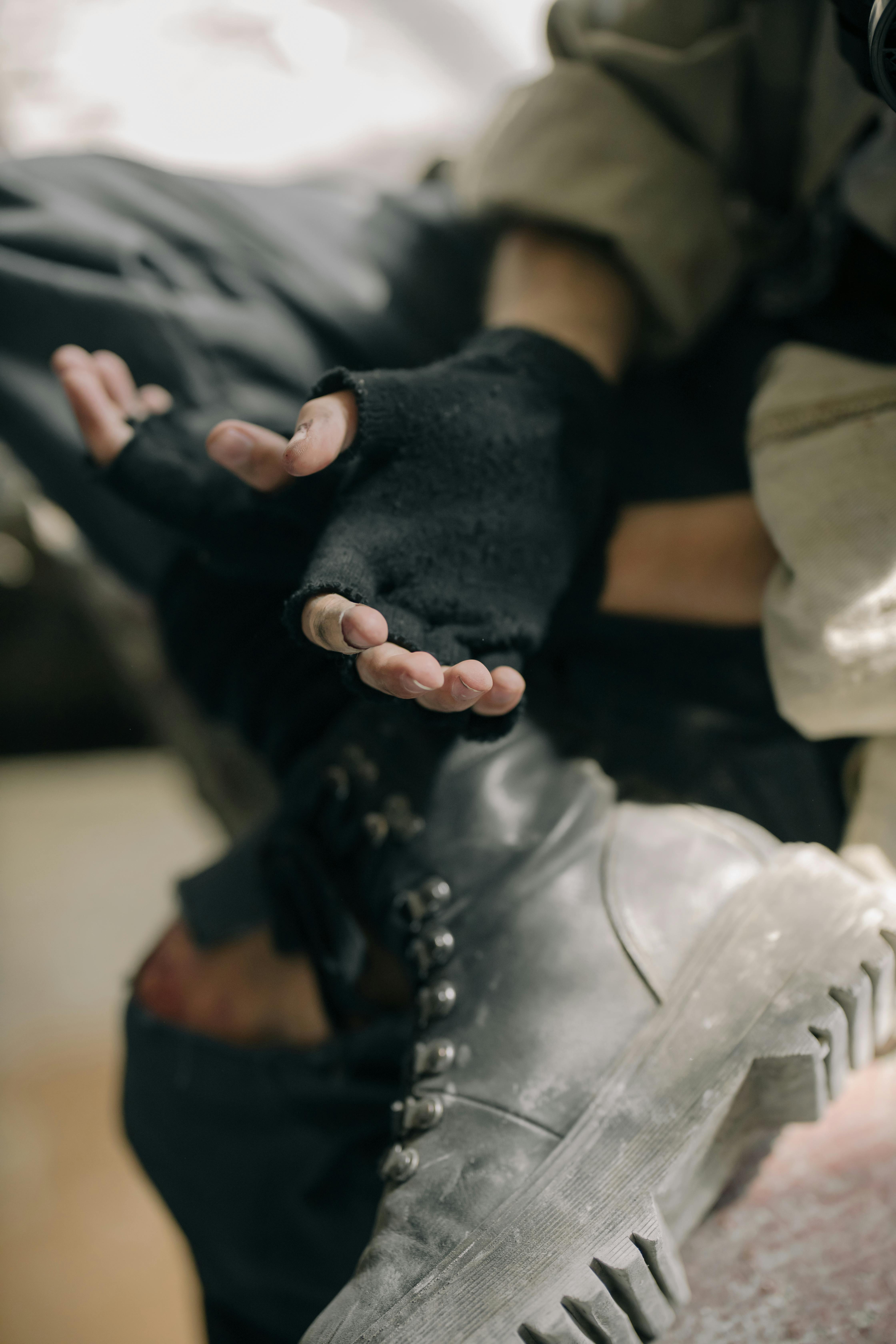 person in black gloves holding black gloves