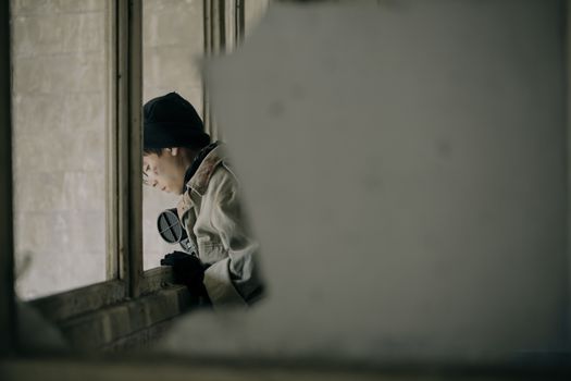 一个孤独的人透过破窗，从一栋腐烂的建筑物里向外张望