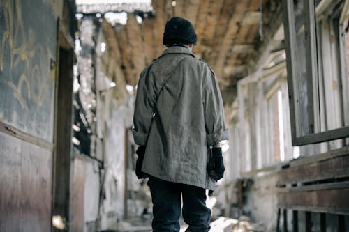 無料 木製の橋の上に立っている黒いニット帽と茶色のジャケットの男 写真素材