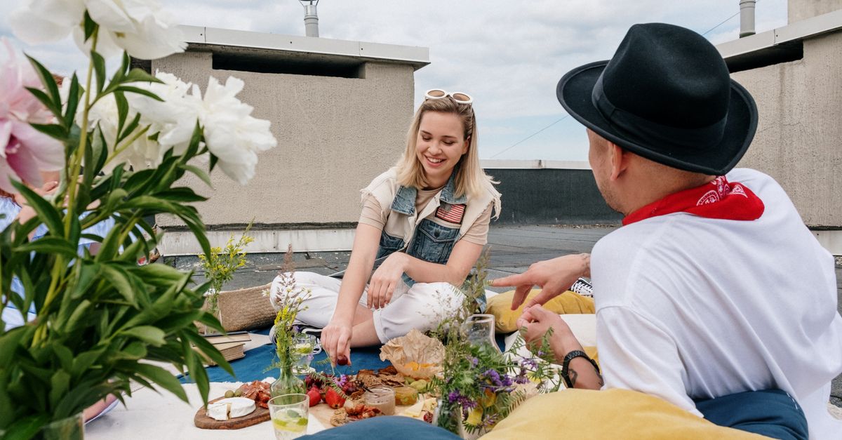 A cheerful group of friends enjoying a summer picnic on a rooftop, capturing leisure and friendship outdoors.