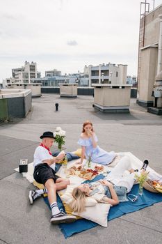 A vibrant rooftop picnic with friends enjoying leisure time in an urban setting.