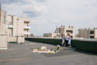 一群朋友在城市屋顶上，趁着晴朗的天空享受夏季野餐