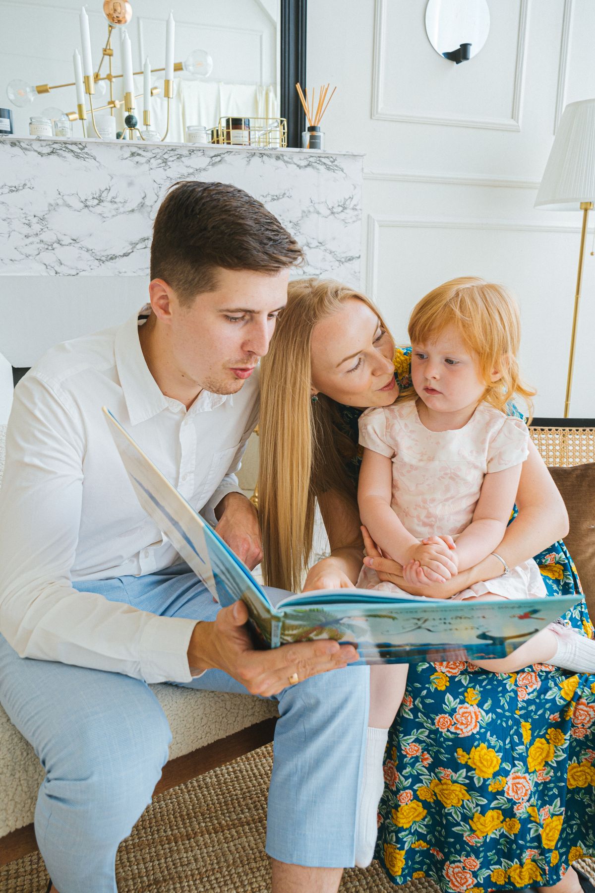 Parents reading a book with a young child at home