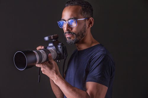 Man in Blue Shirt Holding Black Camera