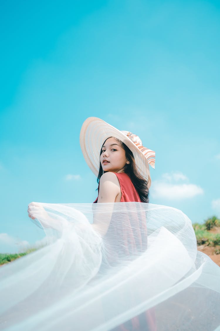 Stylish Asian Teenager In Hat With Flying Cloth On Street