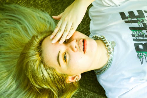 A Woman Lying on Ground Covering Her Eye