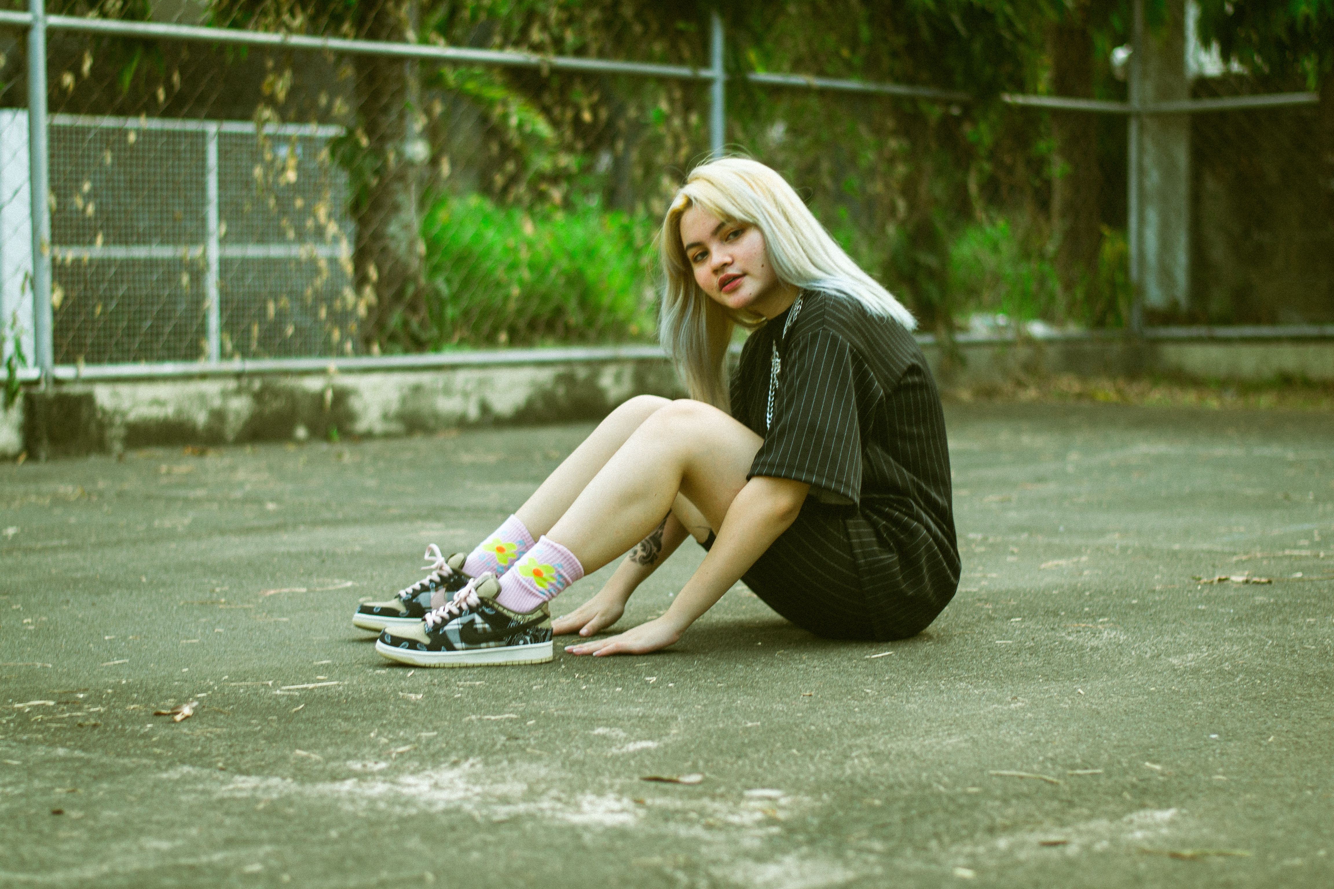 A Girl in Black Dress Sitting on the Ground · Free Stock Photo