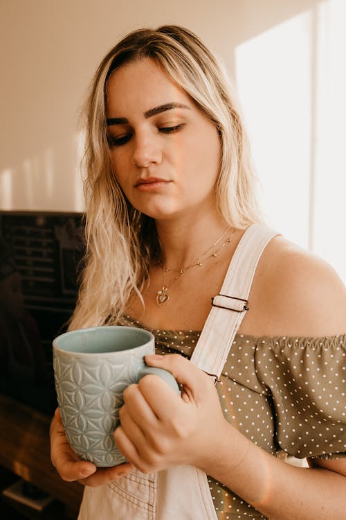 Free Thoughtful woman with mug at home Stock Photo