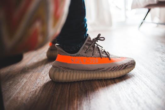 Crop unrecognizable person in modern sport sneakers standing on parquet floor in light room