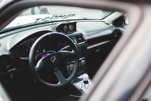 Free Big round black steering wheel in big spacious cabin of luxurious sports car in daylight Stock Photo