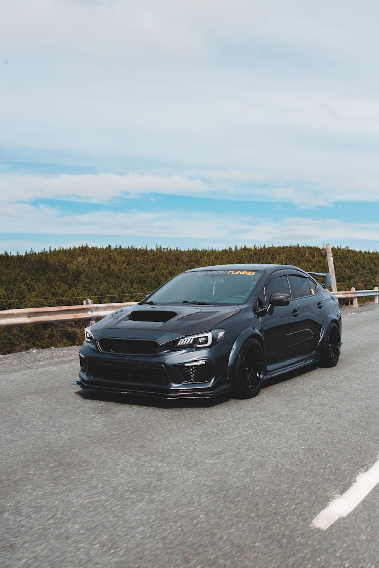 Tuned Sports Car On Paved Road Under Blue Sky