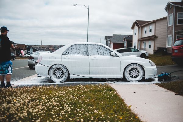 Pressure washer rinsing soap off a vehicle