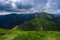 Green Grass Field and Mountains Under White Clouds