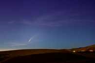 在华盛顿州韦纳奇美丽的夜空中，彗星飞过山丘，被完美的天文摄影捕捉