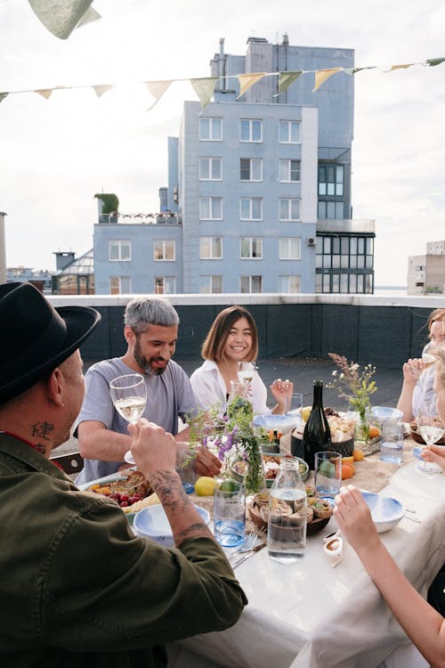 Man and Woman Sitting on Chair in Front of Table With Food