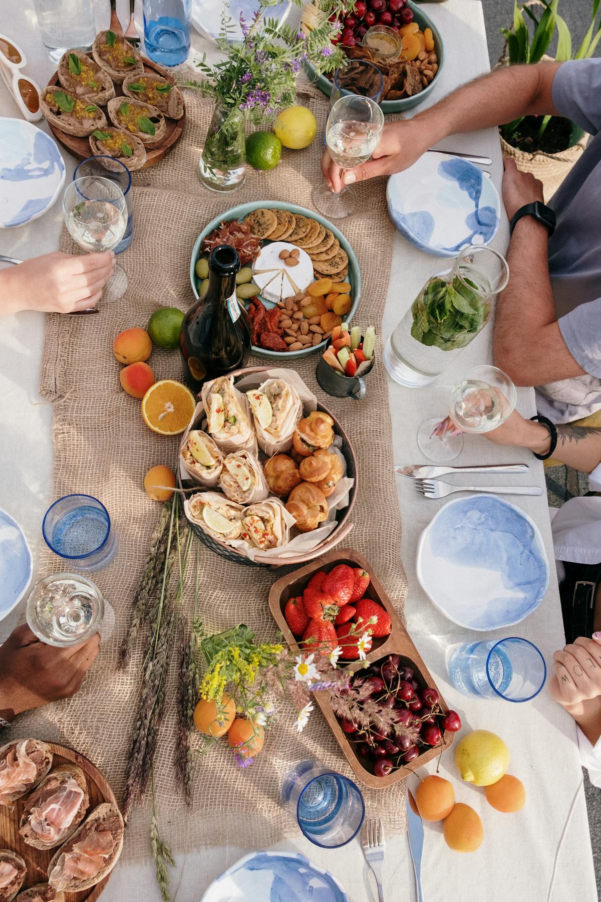 朋友们在野餐时举杯红酒 法式晚宴户外摄影师记录一群朋友吃午餐高清摄影大图-千库网