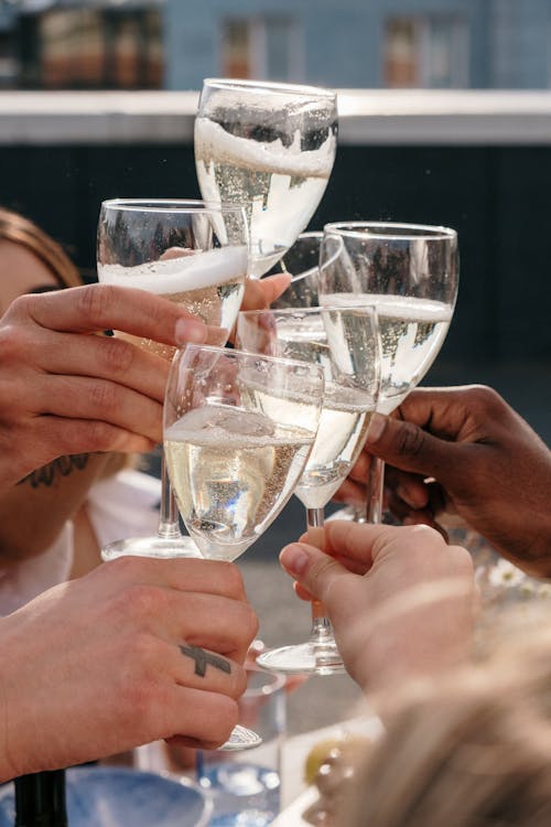 People Holding Clear Wine Glasses