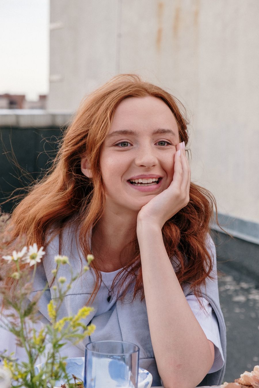 Woman smiling peacefully outdoors among flowers