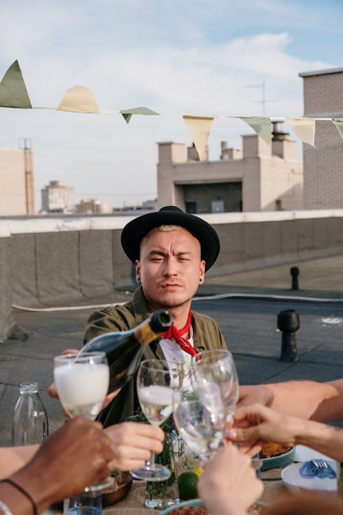 Man in Black Hat and Brown Jacket Sitting on Chair