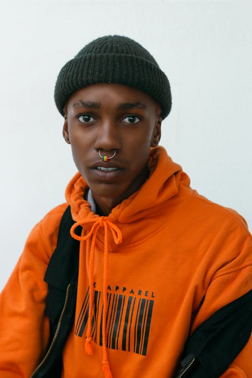 Man in Orange Hoodie Wearing Black Knit Cap