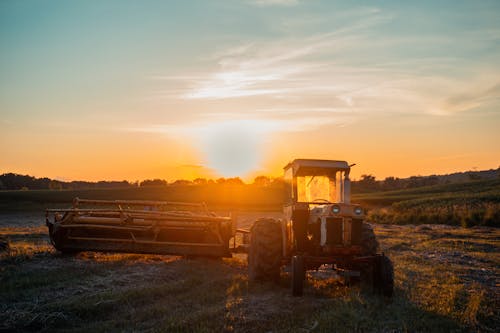 Silhouette Of Tractor On Field During Sunset