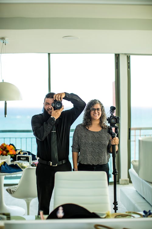 Cheerful photographers taking photo on photo camera in modern interior