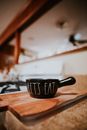 Creative ceramic soup bowl with handle and inscription Lets Eat placed on wooden cutting board in kitchen