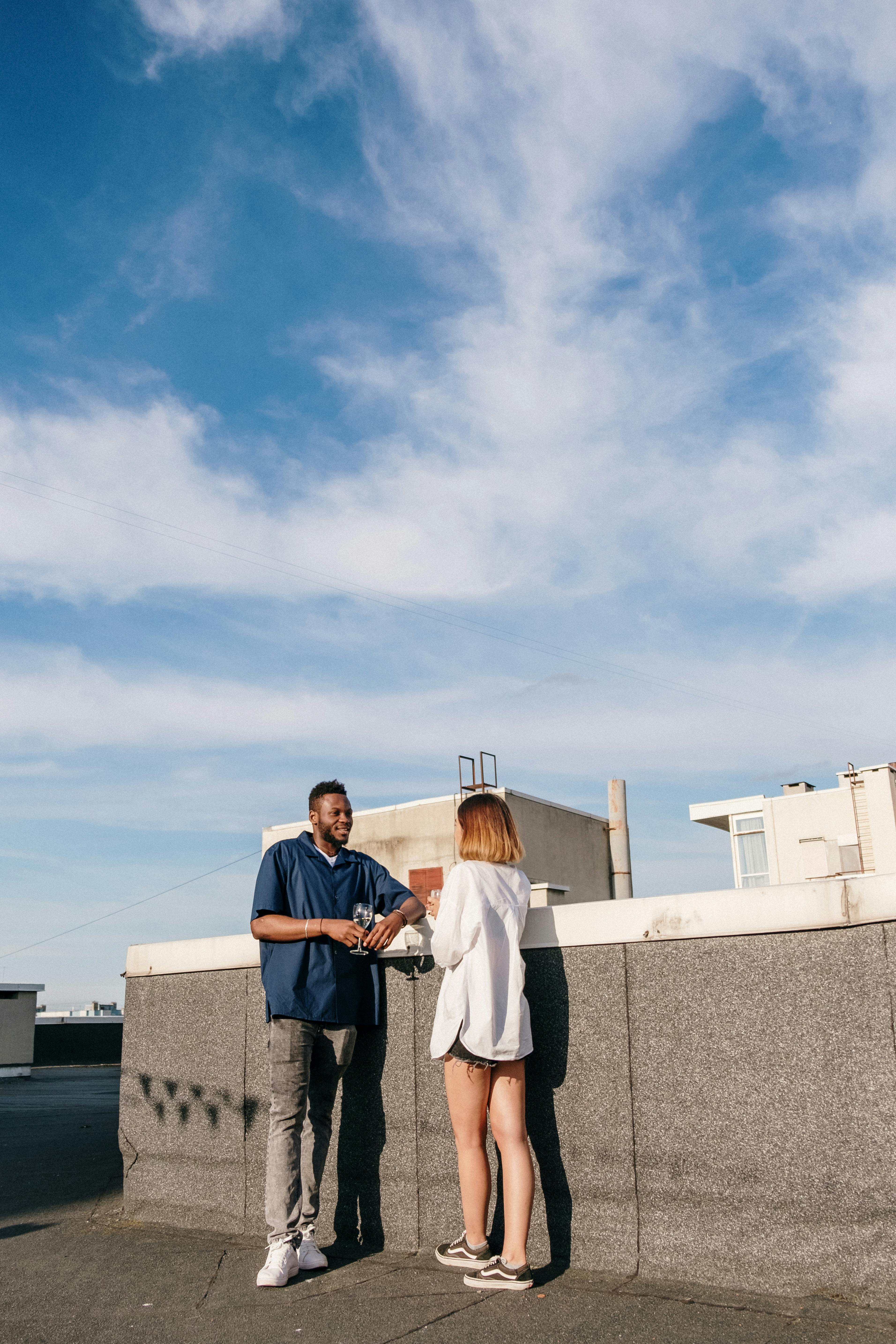 man and woman standing on top of building