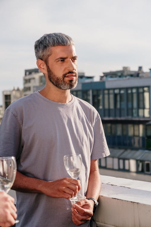 Man in White Crew Neck T-shirt Holding Clear Drinking Glass