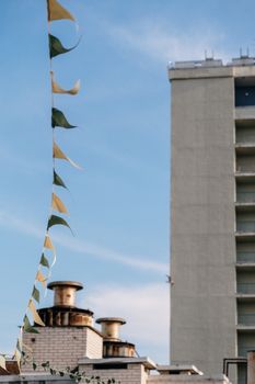 晴朗的天空下，装饰性的彩旗和城市建筑营造出节日气氛