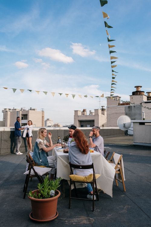 Free A group of friends enjoying a meal on a rooftop with city views and summer vibes. Stock Photo