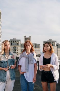 三名女性在城市屋顶上休闲社交，充满夏日氛围