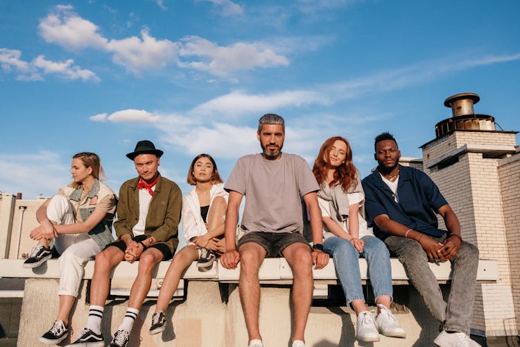 Group Of People Sitting On White Concrete Bench