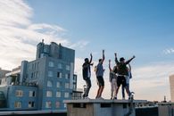 日落时分，一群充满活力的朋友在屋顶派对上跳舞、享受