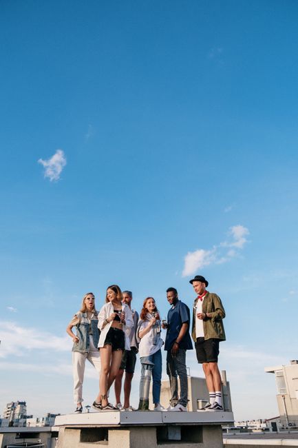 Young adults enjoying a sunny summer day on a rooftop, symbolizing urban togetherness and leisure.