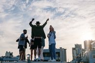 朋友们一起在阳光明媚、可欣赏城市景观的屋顶上庆祝
