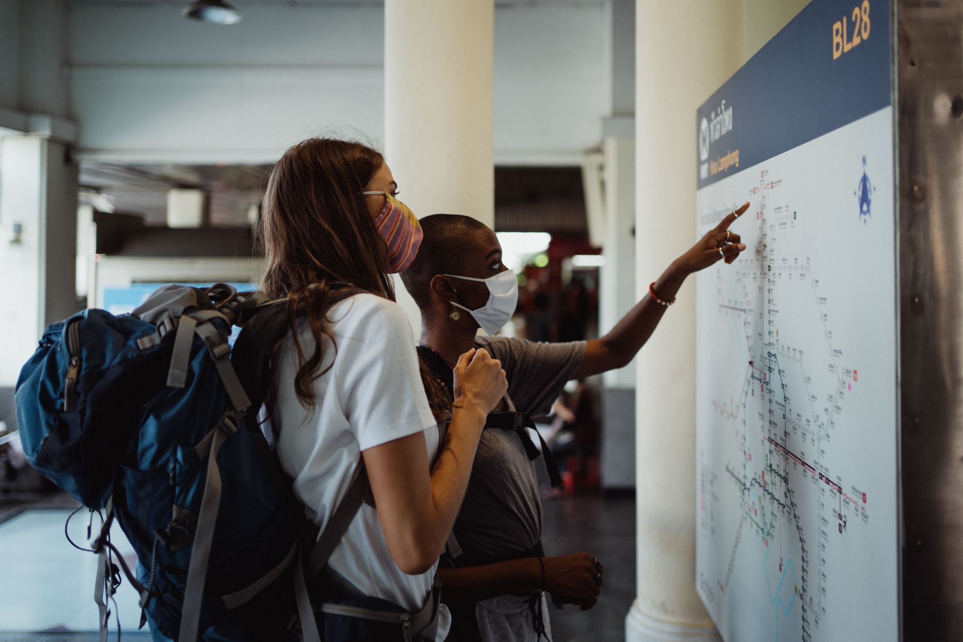 Traveler checking a city transit map near a station