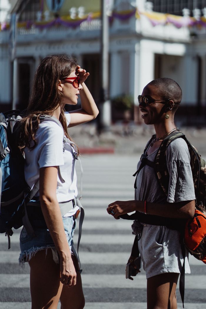 Two travellers meeting on a street corner — photo by Ketut Subiyanto on Pexels