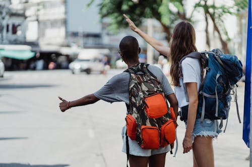 Man In Blue And White Shirt And Orange Shorts Carrying Orange Backpack