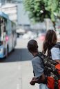 Man in Black Jacket Carrying Backpack Standing Beside Woman in White Shirt