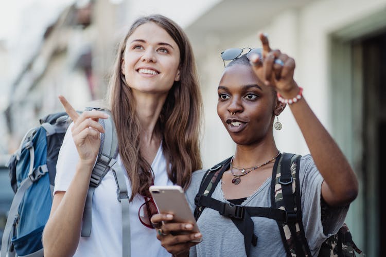 Women With Backpacks Pointing A Direction